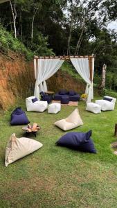 un groupe d'oreillers posés sur l'herbe sous une tente dans l'établissement Casa Aconchego da Serra - Pacoti, à Pacoti