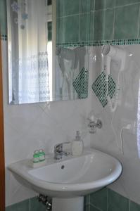 a bathroom with a sink and a mirror at B&B Villa Angelica in Mili Marina