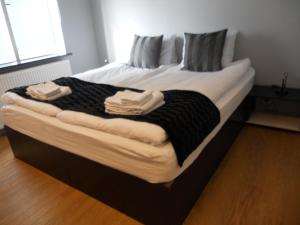 a large bed with two towels on top of it at REK Inn in Reykjavík