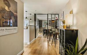 a kitchen and living room with a bar and stools at 3 Bedroom Awesome Home In Faaborg in Fåborg