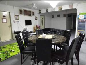 a room with a table and chairs and a television at Airport Riverside Roomstay & Homestay in Kota Bharu