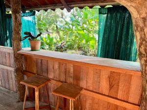 a bar with two stools and a potted plant at El Cerrito in Puerto Jiménez +62 photos