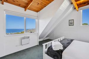 a white room with a bed and a window at Ocean Views 20kms from CBD Sleeps 10 in Kingston Beach