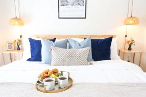 - un plateau de fruits sur un lit avec des oreillers bleus dans l'établissement The Champion's Suite Newly Built Upscale Central, à Gainesville