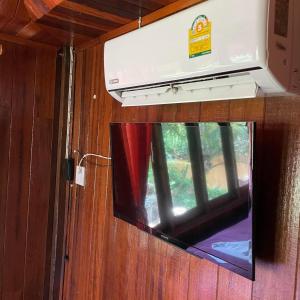 a tv in a room with a window at Healing House Holistic Farm Stay in Ban Wet