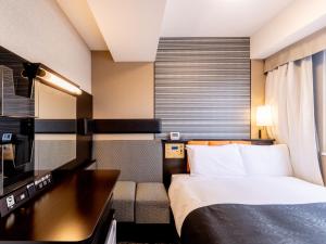 Postel nebo postele na pokoji v ubytování APA Hotel Suidobashi Ekimae