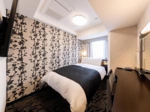 Postel nebo postele na pokoji v ubytování APA Hotel Suidobashi Ekimae