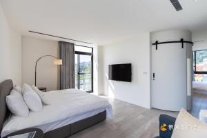 Un dormitorio blanco con una cama y un televisor. en 金湯8號, en Yuanshan