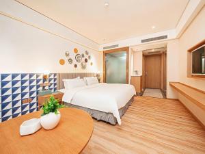 Postel nebo postele na pokoji v ubytování Mediterranean Hotel, Zhangmutou Branch, Dongguan