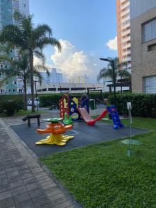 einen Spielplatz in einem Park mit Spielgeräten in der Unterkunft Apto da Sol - 200m da Praia, Estacionamento e Wi-Fi in Praia Grande