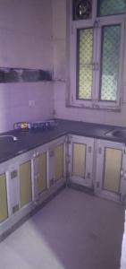 a kitchen with white and yellow cabinets and two windows at श्री कृष्णा होम स्टे in Vrindāvan