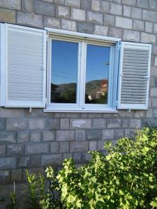 a window on a brick building with a cat in it at Guest House Konak kod Danke in Trebinje