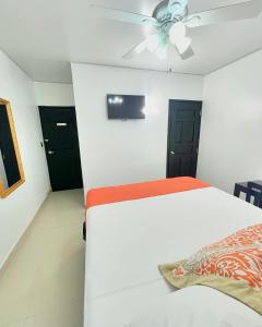 a bedroom with a bed and a ceiling fan at Hotel Reynieri in Comayagüela