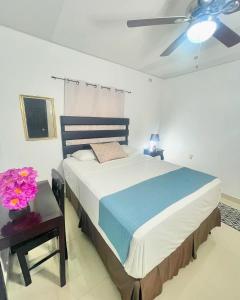 a bedroom with a large bed and a ceiling fan at Hotel Reynieri in Comayagüela