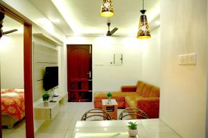 a living room with a couch and a bed at The Aster Apartment in Trivandrum
