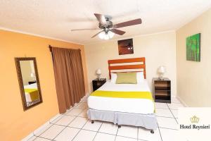 a bedroom with a bed and a ceiling fan at Hotel Reynieri in Comayagüela