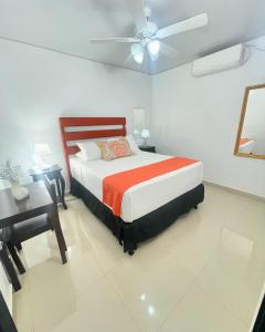 a bedroom with a bed and a ceiling fan at Hotel Reynieri in Comayagüela