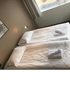 a bedroom with a bed with white sheets and a window at North Star Apartments Rif in Snæfellsbær