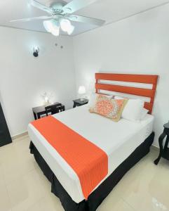 a bedroom with a bed and a ceiling fan at Hotel Reynieri in Comayagüela