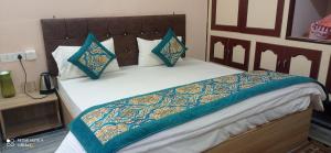a bed with blue and white pillows on it at Unnati Residency in Varanasi