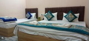 two beds in a room with towels on them at Unnati Residency in Varanasi +7 photos