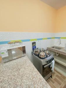 a kitchen with a stove and some pots and pans at Family Apartment in San Cristóbal with 2 Bedrooms, 4 Beds, Living Room, Dining Area, Kitchen, Satellite WiFi and 1 Bathroom with Hot Water - CoralBay - Galápagos Home in Puerto Baquerizo Moreno