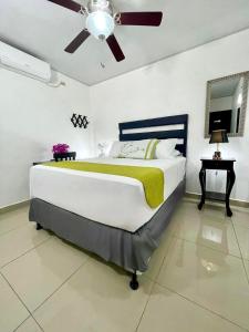 a bedroom with a large bed with a ceiling fan at Hotel Reynieri in Comayagüela