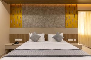 埃罗德Rathna Residency的卧室里有一张大床，配有白色枕头