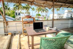 un ordenador portátil sentado en una mesa en un patio en Native by Cliff and Coral, en Varkala 9 fotos más