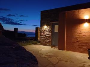 a stone building with a door at night at ARIA Kea Sunset Homes in Ioulis