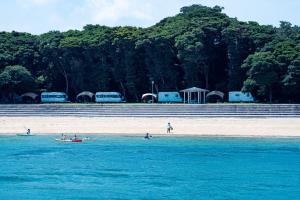 un grupo de personas en el agua en una playa en 長崎鼻ビーチリゾート, en Kakaji