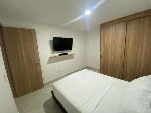 a bedroom with a bed and a flat screen tv at Apartamento Sabaii 201 in Cartagena de Indias +1 photo