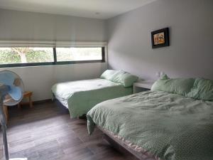 ein Schlafzimmer mit zwei Betten und einem Fenster in der Unterkunft CASA MOSHI in Malinalco + 18 Fotos
