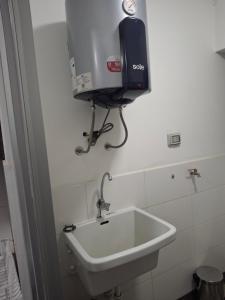 a bathroom with a sink and a tv on the wall at Alojamiento Familiar en zona exclusiva de Chiclayo in Chiclayo