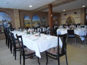 a dining room with white tables and black chairs at Domus Viatoris in Sahagún