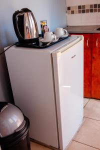 una cocina con un microondas encima de un refrigerador en African Apartments Inn, en Kasane Airport