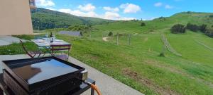 a television sitting on a porch with a view of a field at Vue exceptionnelle tout en haut des montagnes, dépaysement total ! in Camurac