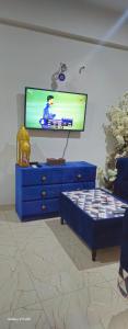 a living room with a tv and a blue dresser at Serenity Inn in Islamabad