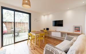 a living room with a couch and a table at Villa Cocoon Contis pour 2 - Jardin privatif - 900m Océan in Lit-et-Mixe