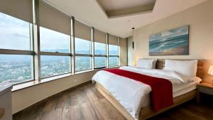 a bedroom with a large bed with large windows at Luxury Centaurus Apartments Islamabad in Islamabad +49 photos