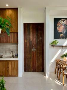 een keuken met een houten deur en een tafel bij The Green Atelier Bali in Jimbaran +8 foto's