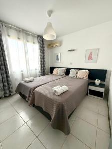 a bedroom with a bed with two towels on it at Irenes Apartment in Larnaca