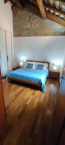a bedroom with a bed with blue sheets on a wooden floor at Urban 34 - station & centre in Treviso