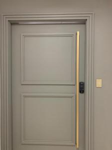 une porte blanche avec une poignée en bois sur elle dans l'établissement Unitá Tower - Luxury Apartment, à Belém