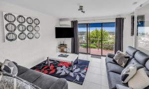 a living room with a couch and a table at 2 Bedroom - 2 level apartment - Hydra Holiday Unit 2, Merimbula in Merimbula