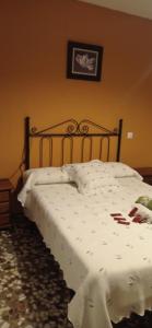 a bedroom with a bed with a white comforter at Apartamentos cañamares in Cañamares