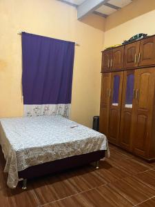 a bedroom with a bed and a blue curtain at Casa Coelho season for cop30 in Marituba
