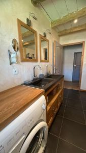 a kitchen with a sink and a washing machine at Gîte Le Verger in Traize +31 photos