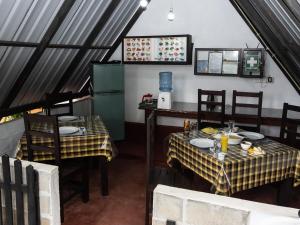 a dining room with two tables and a kitchen at Lake Wind in Habarana +77 photos
