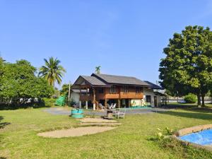 a house with a pool in front of it at Regal Eagle Guesthouse -Thai House and Garden in Chiang Mai